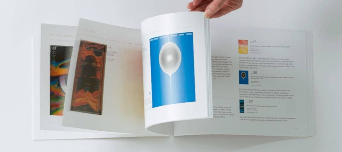 A hand flipping through a design book