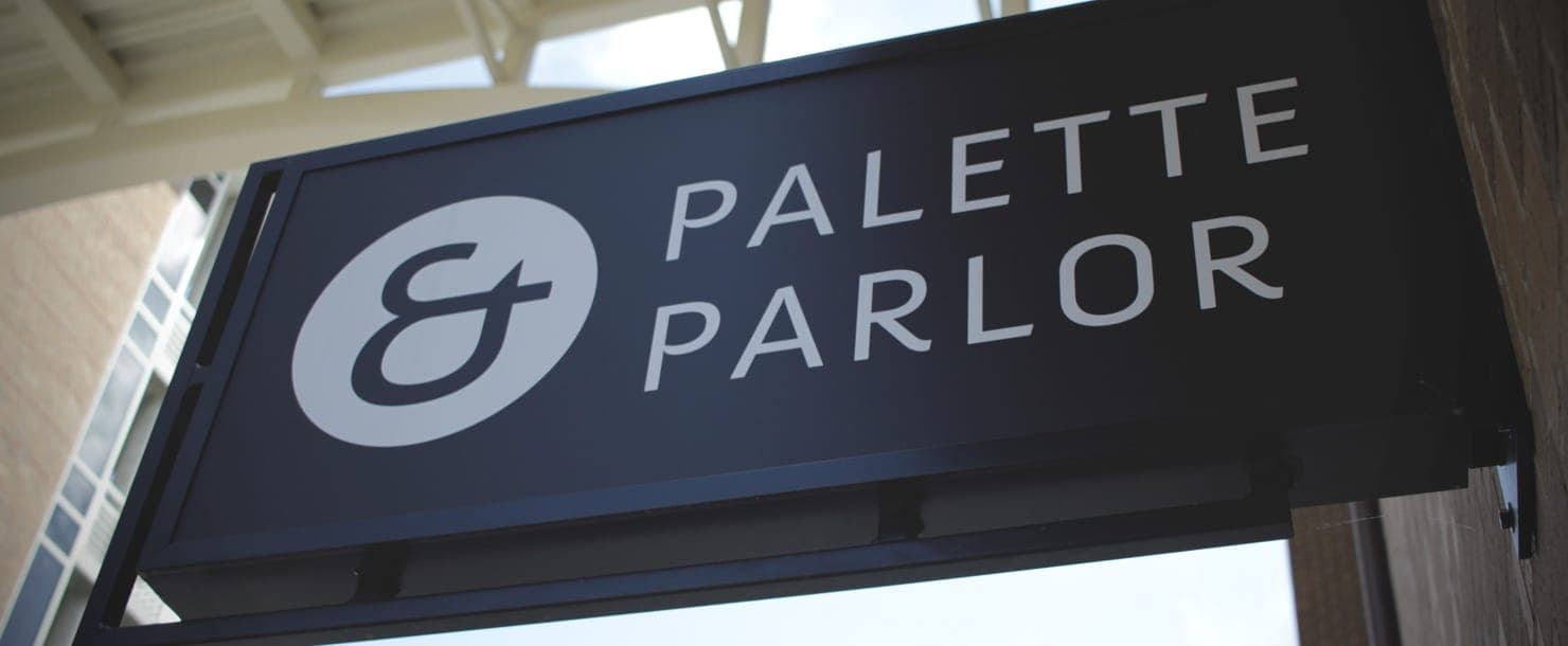 Hero image of a sign showing the Palette & Parlor logo